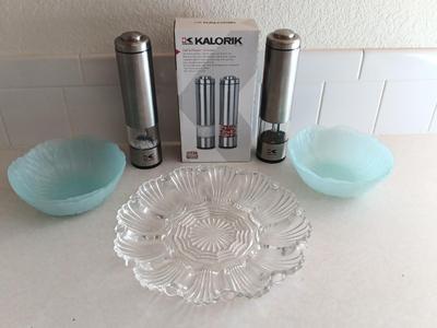 Kalorik salt & Pepper grinders and four light blue plastic salad bowls and a glass egg plate