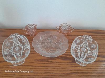Pink depression glass with two divided pressed glass dishes and a rose patterned dish