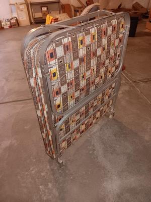 Folding easy store metal framed rollaway bed.