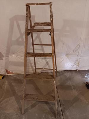 5' wooden ladder with an orange extension cord on a reel