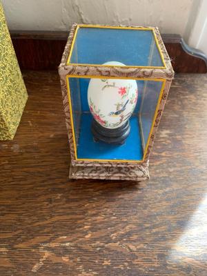 Vintage hand painted Chinese egg in a glass display case