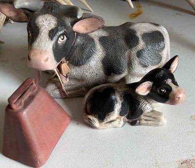 Laying down cow with calf a cowbell