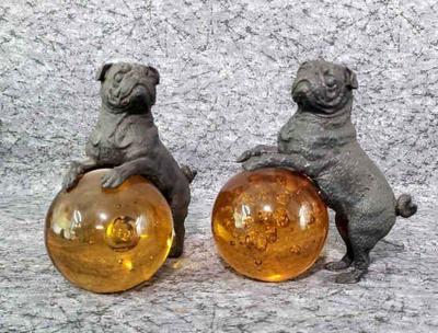 Cast iron pug dog on amber glass ball paperweights