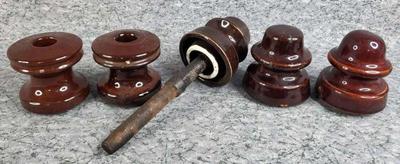 Antique brown ceramic insulators one with pole still attached