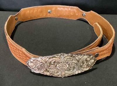 Tooled leather belt with a silver buckle