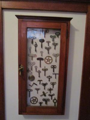 Sale Photo Thumbnail #44: Oak wall cabinet with glass door, 15"Wx30 1/2 H, Latches.  Shown here displaying clock keys.