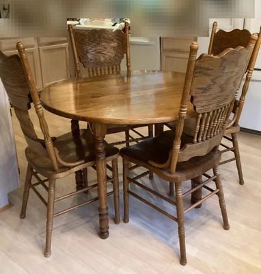 Round wooden dining table with four chairs