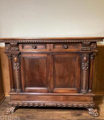 An italian baroque carved walnut cabinet with paw feet