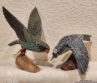 2 colorful wooden birds on a perch