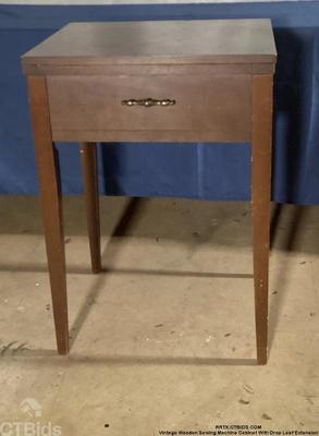 Vintage wooden sewing machine cabinet with drop leaf extension