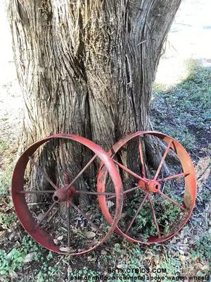 A pair of antique red metal spoke wagon wheels