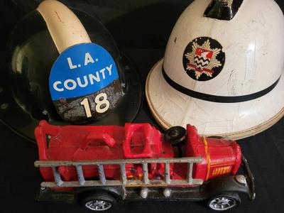 PAIR OF VINTAGE FIREMAN HELMETS AND A CAST IRON FIRE TRUCK 