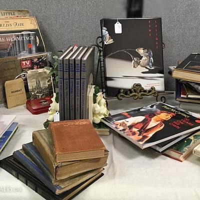 A large table of books -- not your ordinary beach read paperbacks; works of historic, aesthetic, educational interest