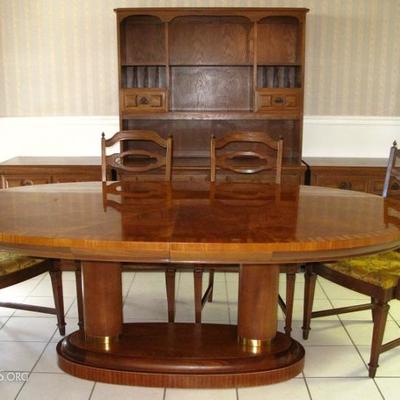 Oval Dining Room Table on Dual Column Base w/leaf shown on the right wall.  There are  4 Side and 2 Arm Chairs.  Pictured in the...