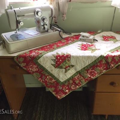 Jenome New Home Portable Sewing Machine, Handcrafted Quilted sit atop a small Formica Topped Desk