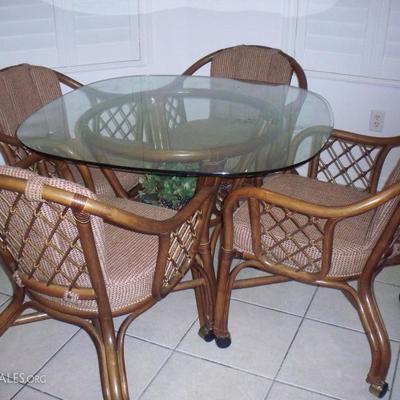 Rattan and glass top table with 4 chairs on casters