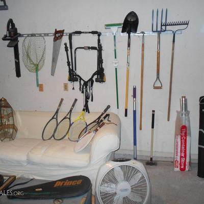 A large garage with many gardening hand tools