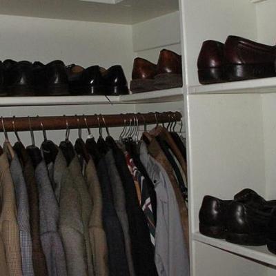 Men's closet showing several pairs of dress shoes and suits & suit jackets