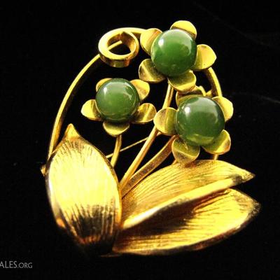 Gold tone brooch with jade stones.