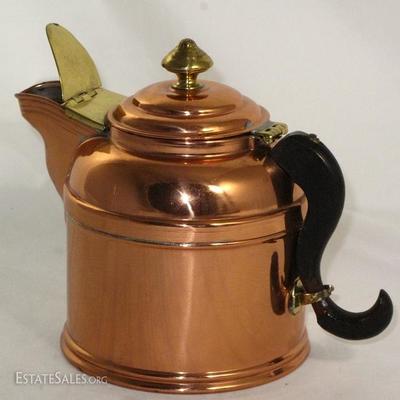 Copper tea kettle with brass fittings and black handle.