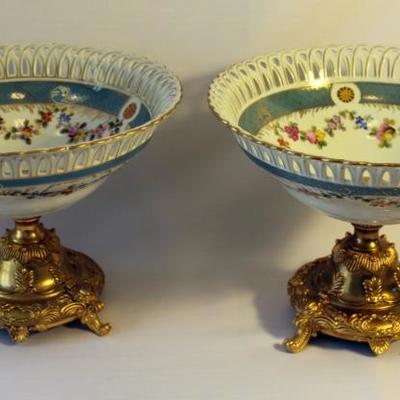 Pair of porcelain compotes with floral design on gilded bronze mount bases. Size: 8.25