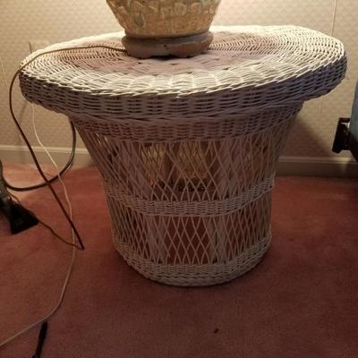 Wicker end table. There are also two chairs and a sofa in other rooms.