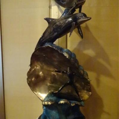 LARGE PATINATED BRONZE SCULPTURE, SURFER WITH WAVE AND 2 DOLPHINS