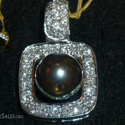 close up black pearl diamond enhancer in platinum