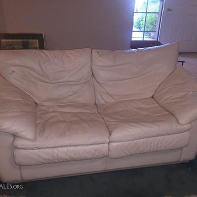 supple white leather loveseat.  almost new!  we have two foe sale