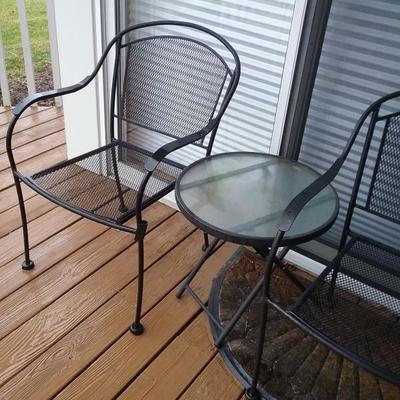 two patio chairs metal, and round glass side table