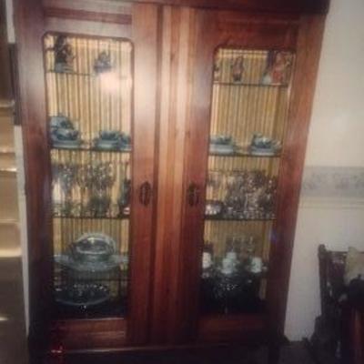 Antique armoire repurposed into china cabinet with glass shelves and lighting. Fragile to move