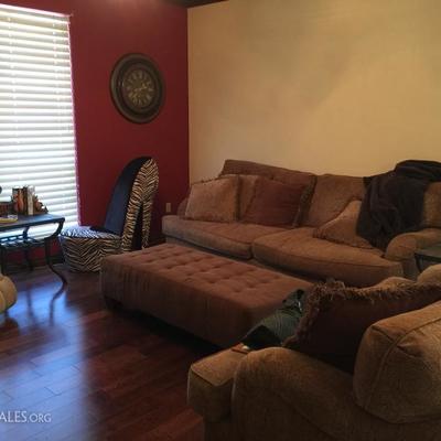 Living room has a sofa, loveseat, ottoman, and slate top end tables