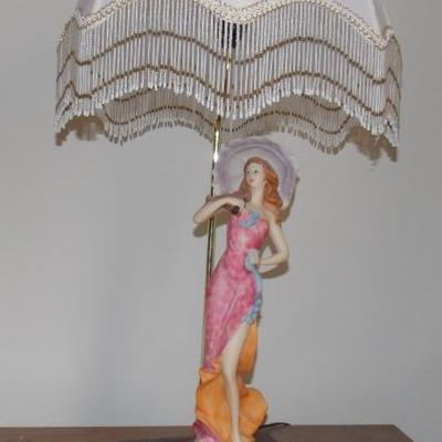 There are three different figural lamps with fringed shades