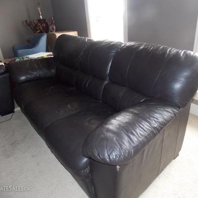 Black leather couch, matching love seat is pictured in a later image.