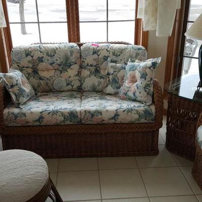 4 piece wicker set includes loveseat, chair and 2 side tables along with floral cushions