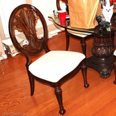 double pedestal glass top table with six beautifully carved white upholstered chairs.