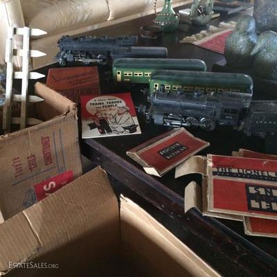 Close view of pre-war Lionel o-guage trains, tracks & some fencing