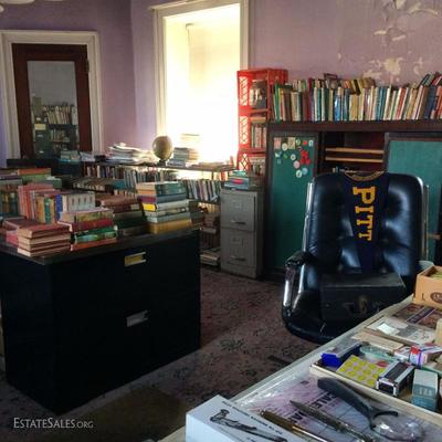 Packed writer's office filled with rare, antique and vintage books, vintage office supplies and furniture and a collection of...