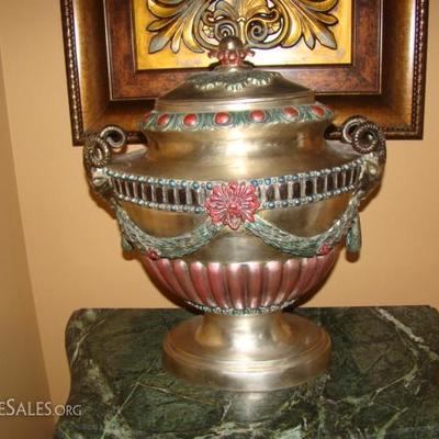 Neo classical Cold Painted Bronze Urn with domed lid flanked by rams heads joined by a stylized floral garland, the lobbed body is raised...