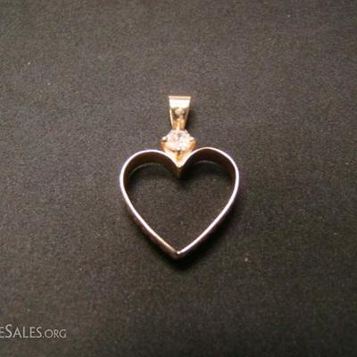 Ladies 14 kt. charm. Formed by using a man's wedding ring shaped into a heart.  Diamond insert.  Weighs 3 grams.  