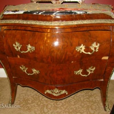 A Louis XV-style ormolu mounted *bombe commode. Black and white serpentined marble top above a conforming case with two drawers, corners...