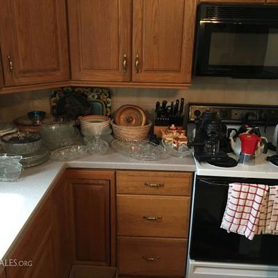 Decorative bowls, serving dishes, coffee appliances on stove