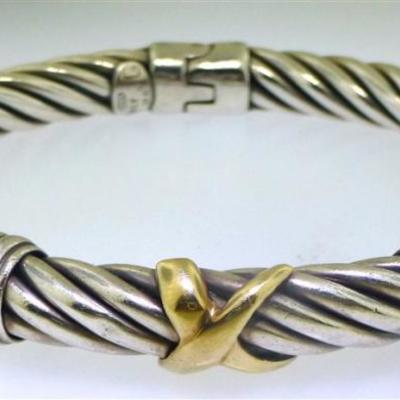 Lot 97 - Sterling silver & 18kt yellow gold rope design bangle bracelet. The bracelet measures approx. 7.40mm wide and has a twisted rope...