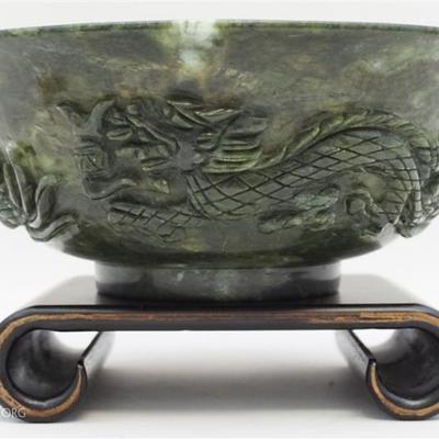 Lot 112- Chinese Jade Bowl Carved with Dragons. The Bowl of a dark spinach green color, slightly everted rim, circular foot. Three carved...