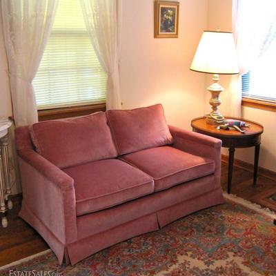velveteen loveseat, oval side table with drawer and raised brass trim, silvery lamp, painting, wool oriental style carpet