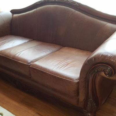 Brown leather sofa with wooden detailing 