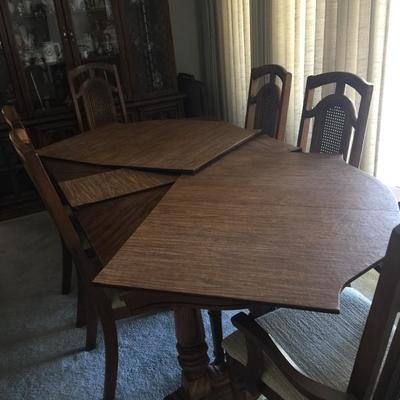 Solid wood dining table with 2 leaves. Sits 6 w/o leaves. 10/12 with leaves in. Also has protective pad 