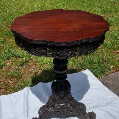 Antique mahogany tilt top table, intricately carved flowers on feet, column & table skirt. 30x23 inches
