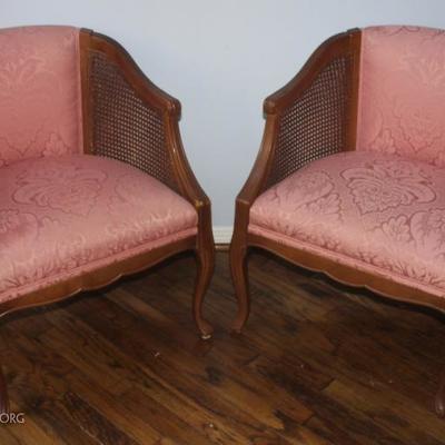 pair of upholstered armchairs with cane arms
