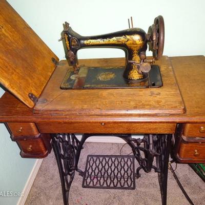 singer hand crank sewing machine and cabinet from the early 1900's